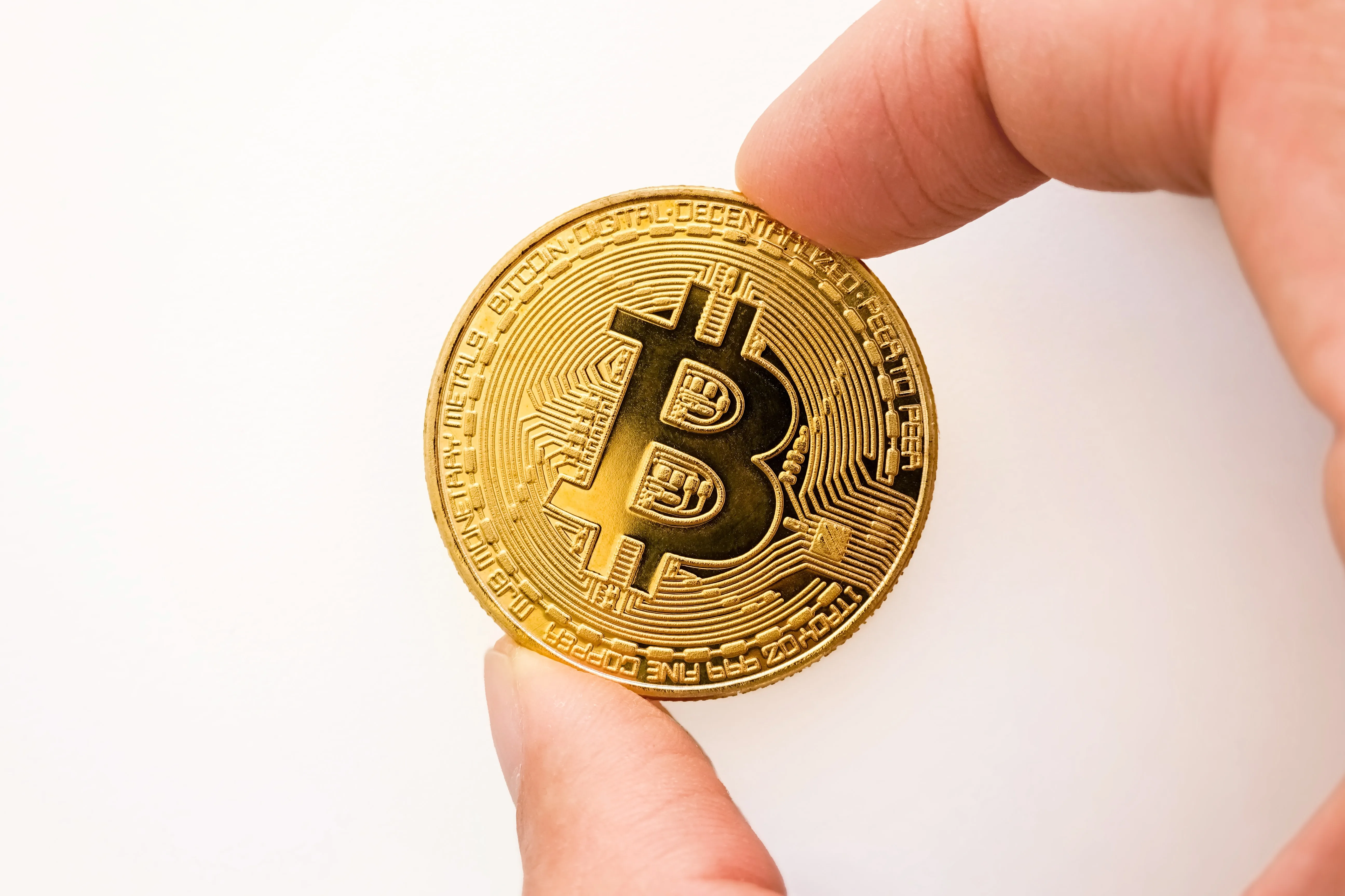 Bitcoin gold coin held by two fingers - Jeremy Bezanger on Unsplash