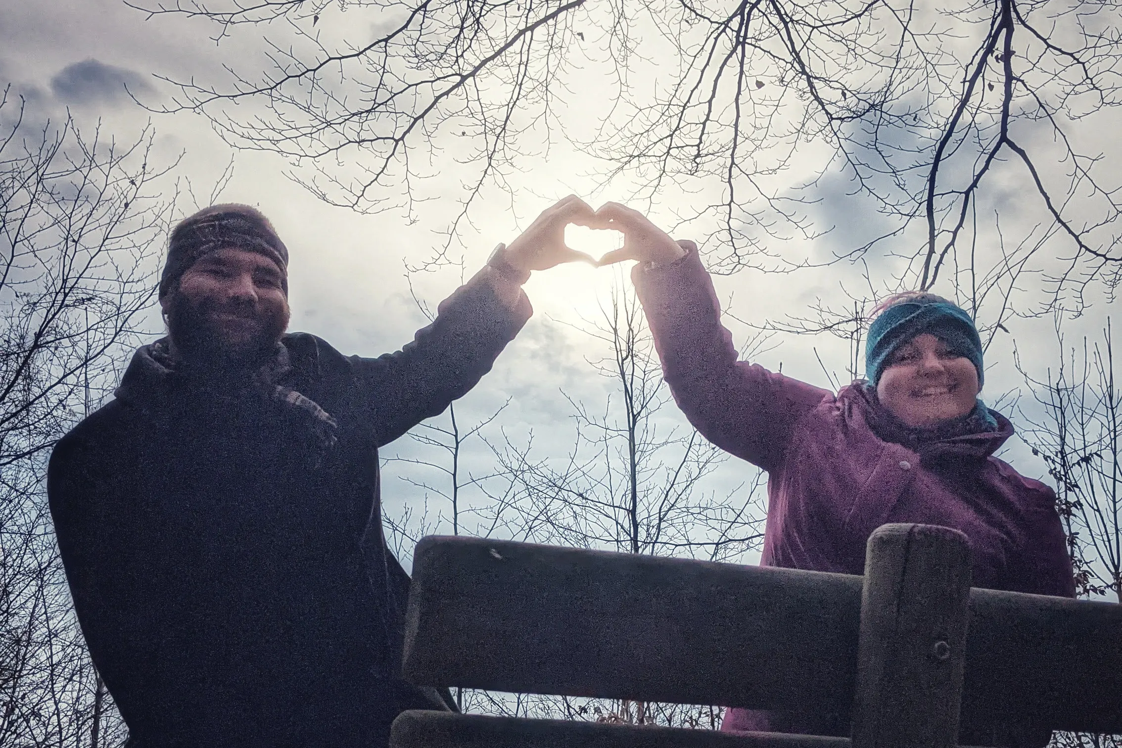 Christin and Thomas miming a heart infront of the sun